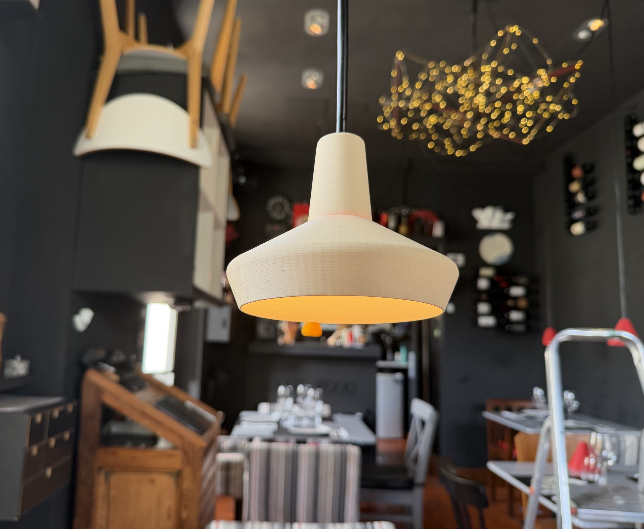 Pendant lamp installed in a restaurant interior, warm ambient light.